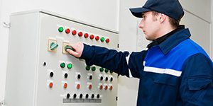 engineer operating an industrial electrical control panel